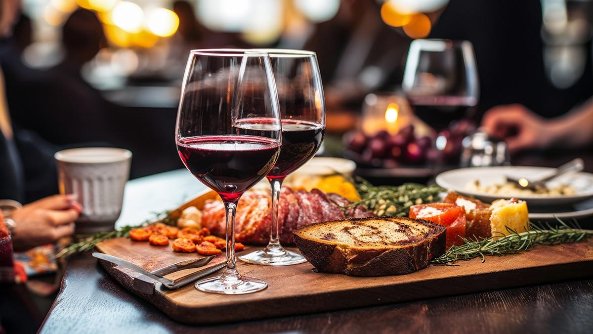 Article Cards Featured Image Close up of a glass of red wine on a bar table with blurred peop