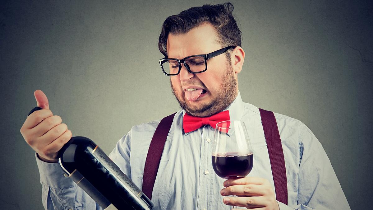 Article Cards Featured Image Man tasting wine and looking at bottle