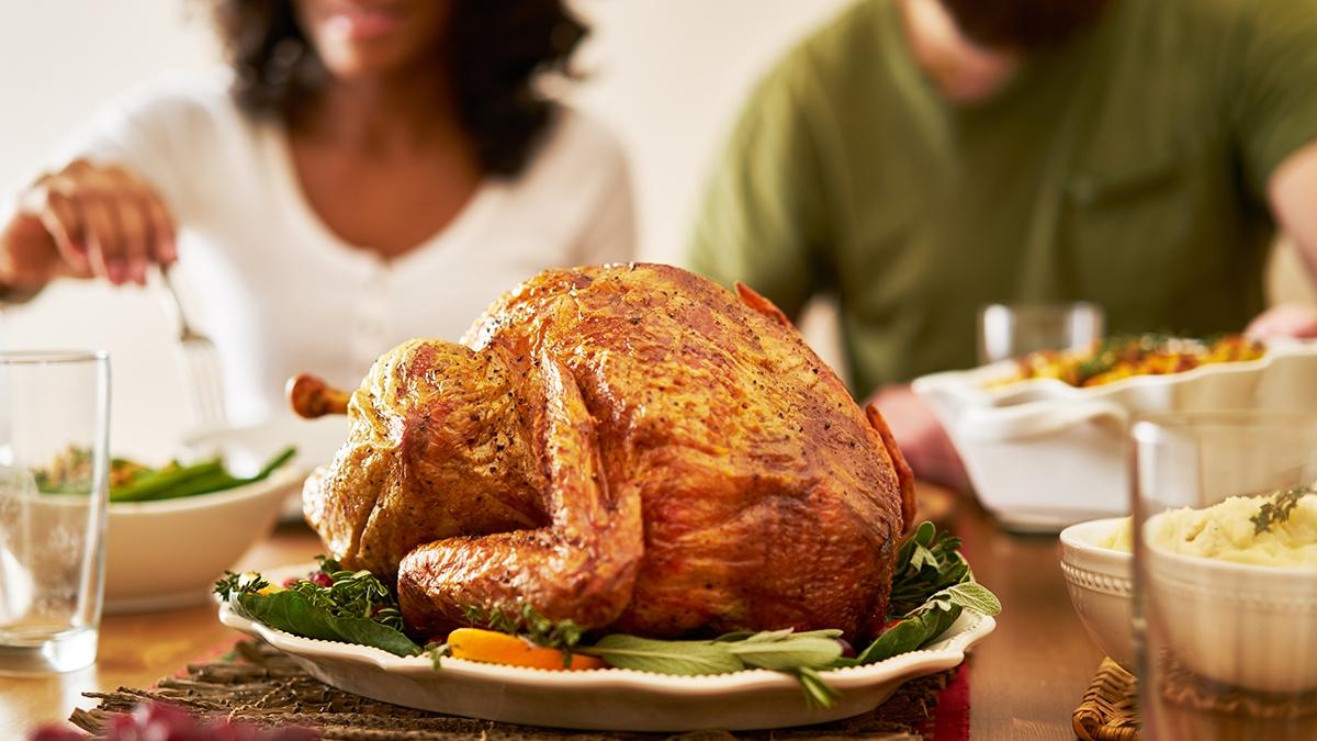 Article Cards Featured Image thanksgiving dinner turkey with people eating