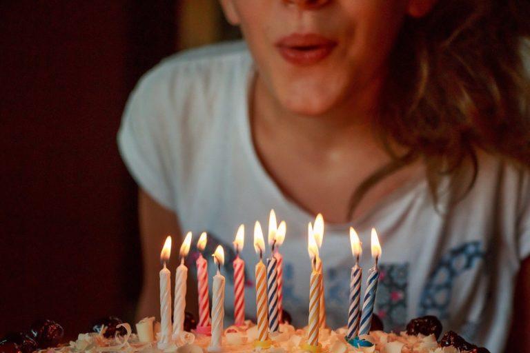 Birthday traditions image   woman blowing out birthday candles