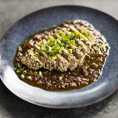 Plate with sliced tuna steak with sauce for Father's Day recipes.