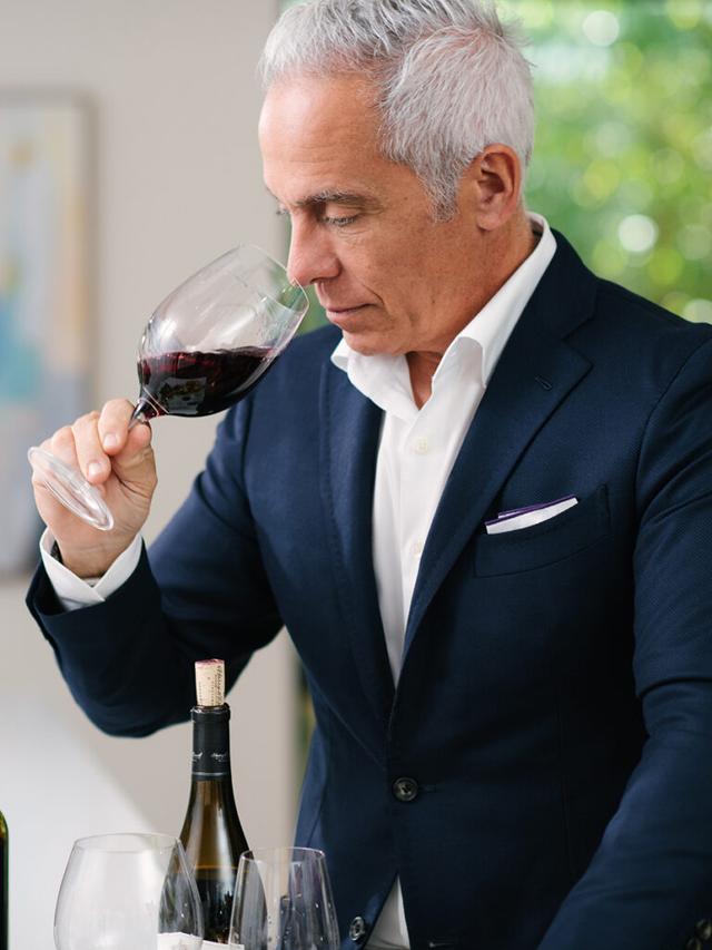 Geoffrey Zakarian sniffing a glass of pinot noir.