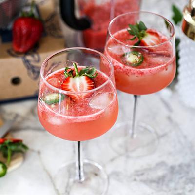 Two strawberry cocktails on a marble counter.